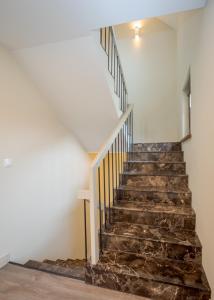 a staircase in a house with a stone stair case at Amberton Villas in Karklė