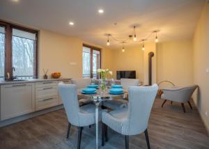 a kitchen and dining room with a table and chairs at Amberton Villas in Karklė