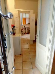 a bathroom with a door and a tile floor at Villetta Rosa in Lavena Ponte Tresa