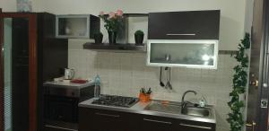 a kitchen with a stove, sink, and refrigerator at Airport Orchid in Olbia