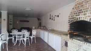 cocina con mesa, sillas y chimenea en Suítes Xodo Tour, en Arraial do Cabo