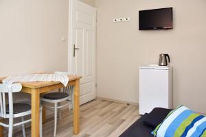 Kleines Zimmer mit einem Tisch und einem kleinen Kühlschrank. in der Unterkunft NORDA in Kuźnica