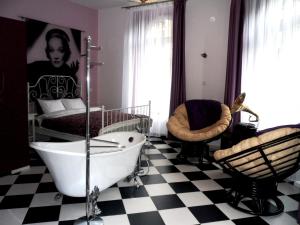 1 dormitorio con 1 cama y baño con bañera. en Apartamenty Lili & Country, en Cracovia