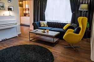 een woonkamer met een blauwe bank en een gele stoel bij Guest House Amaya in Plovdiv