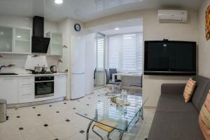a kitchen and a living room with a glass table at 2-room Apartment Lux near Centre Wi-Fi Free in Dnipro