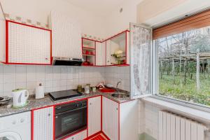 a kitchen with red cabinets and a sink and a window at Casa Aurora in Ravello