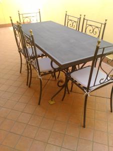 une table et des chaises noires installées à côté d'un sol carrelé dans l'établissement Casa indipendente, à Fiumefreddo di Sicilia
