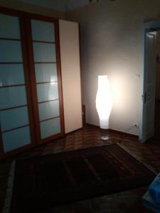 una lámpara en la esquina de una habitación con puerta en Casa indipendente, en Fiumefreddo di Sicilia
