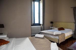 una camera con due letti e una finestra di Soggiorno La Cupola Guesthouse a Firenze