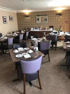 uma sala de jantar com mesas e cadeiras de madeira em Rosehill Guest House em Pitlochry