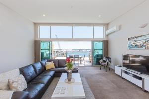 a living room with a couch and a table at 3 Bedroom Penthouse with Fabulous Views in Auckland