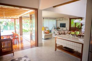 a living room with a kitchen and a dining room at Excelente casa, pé na areia, no melhor de Arraial! in Arraial d'Ajuda