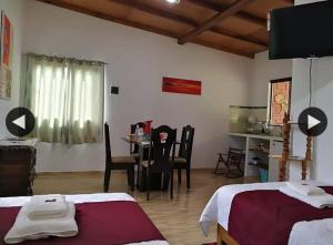 a bedroom with two beds and a table and chairs at Posada Bavaria in Trinidad