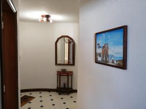 um corredor com um espelho e uma imagem na parede em Albufeira INN - Casa de Viseu - CORAL T1 em Albufeira