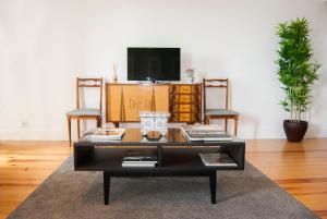 ein Wohnzimmer mit einem Couchtisch und einem TV in der Unterkunft DA'HOME - Vitoria Duplex Apartment in Porto