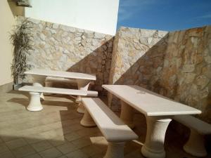 a group of picnic tables and benches against a stone wall at SOL & MAR in Lagos