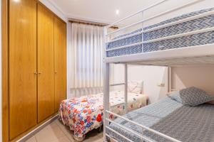 バレンシアにあるPatacona Beach Valenciaのベッドルーム1室(ベッド2台、二段ベッド1組付)