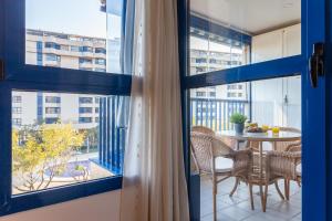 バレンシアにあるPatacona Beach Valenciaのテーブルと椅子、窓が備わる客室です。