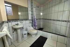 a white bathroom with a toilet and a sink at La Casa de Maruja B&B in Huaraz +16 photos