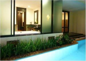 a bathroom with a large mirror and a bath tub at Yodia Heritage Hotel in Phitsanulok