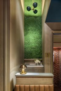 una habitación con una pared verde y un banco con flores en Merrion Row Hotel and Public House, en Nueva York