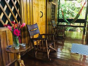 a room with chairs and a vase of flowers on a table at Coral Hill Bungalows in Cahuita