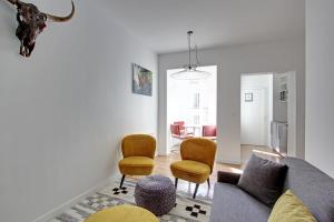 - un salon avec un canapé et deux chaises dans l'établissement Rent a Room - Residence Meslay, à Paris