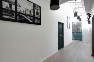 un couloir avec des murs blancs et une porte noire dans l'établissement Rent a Room - Residence Meslay, à Paris