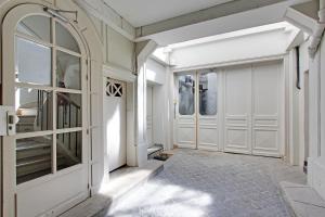 a hallway with white doors and a staircase at Rent a Room - Residence Meslay in Paris