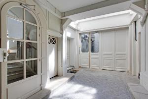 un couloir avec des portes blanches et un escalier dans l'établissement Rent a Room - Residence Meslay, à Paris