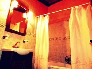 a bathroom with a white shower curtain and a sink at La Casa de los Templarios in Puebla de Alcocer