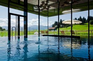 a swimming pool with an umbrella in a building at Hotel Kaufmann in Roßhaupten