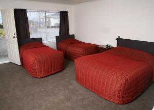 Habitación con 2 camas con reposapiés rojos en Mount Hutt Motels, en Methven