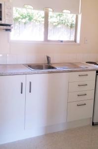 a white kitchen with a sink and a window at Mount Hutt Motels in Methven +4 photos