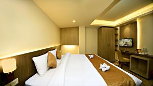 Ένα ή περισσότερα κρεβάτια σε δωμάτιο στο The Milestone Hotel