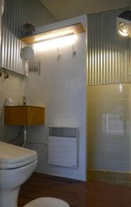 La salle de bains est pourvue d'une douche et de toilettes blanches. dans l'établissement Cat on a Hot Tin Roof, à Yangyang