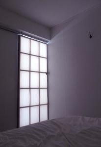 a bedroom with a bed and a large window at Cat on a Hot Tin Roof in Yangyang