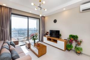 ein Wohnzimmer mit einem Sofa und einem TV in der Unterkunft Gold View APT1/2bed/2bath/free pool and Gym in Ho-Chi-Minh-Stadt