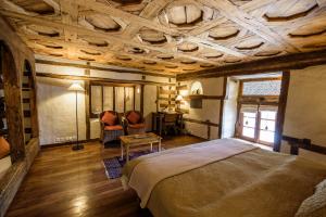 a bedroom with a bed and a table and a desk at Serena Shigar Fort in Shigar