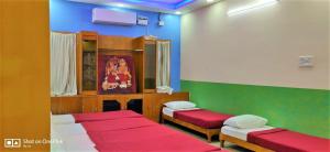 a room with two beds with red and green at Jayaram Residency Servicrd Appartments Tirupathi in Tirupati