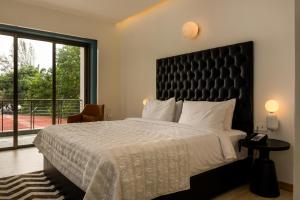 1 dormitorio con 1 cama grande y ventana grande en StayVista Ashore 6BHK Infinity Pool Ocean View- Morjim en Morjim