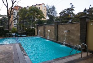 a swimming pool with two water fountains at Reata Apartment Hotel in Nairobi