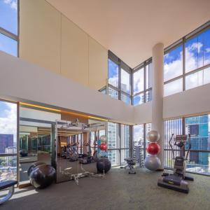 un gimnasio con equipos de ejercicio en un edificio con ventanas en Fraser Residence Orchard Singapore, en Singapur