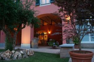 蒙卡尔沃La Locanda del Melograno的院子里有树的粉红色房子