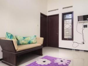 a living room with a chair and a purple rug at Bukir Five in Malang