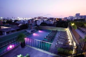 a swimming pool on the roof of a building at night at Chillax Heritage Hotel Khaosan - SHA Extra Plus in Bangkok