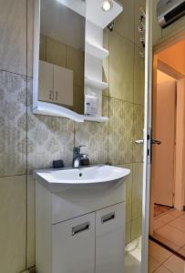 a bathroom with a white sink and a mirror at Apartment Tina in Petrovac na Moru