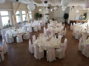 a room filled with white tables and chairs with white linens at Landgasthof Druschel in Schlüchtern