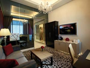 a living room with a couch and a tv at Resorts World Genting - Crockfords in Genting Highlands