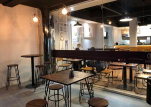 a restaurant with tables and stools and a large piano at Yellow Bee Tanah Abang in Jakarta